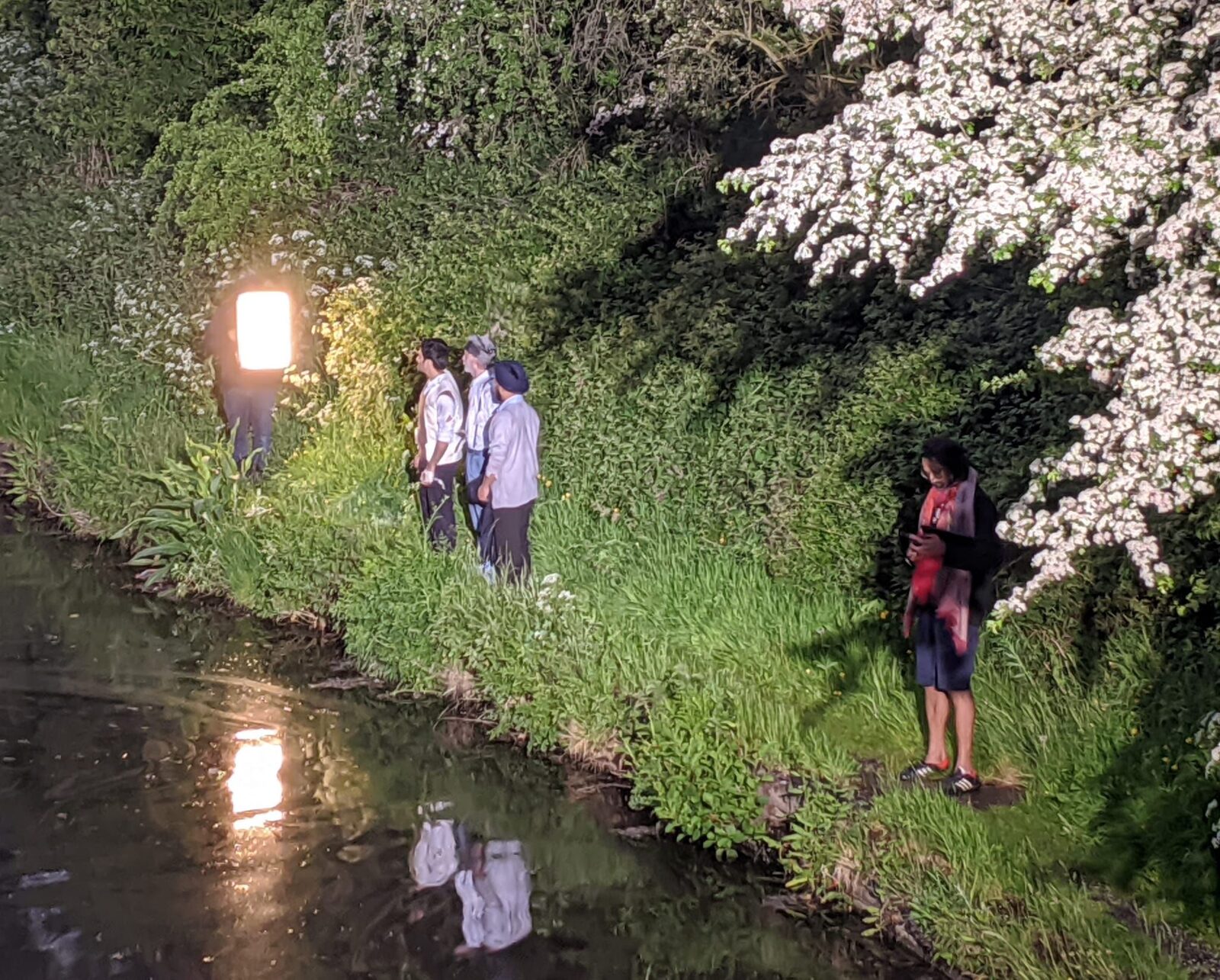 Cast on the canal bank at night with full lighting rig, shooting The Bridge tableau