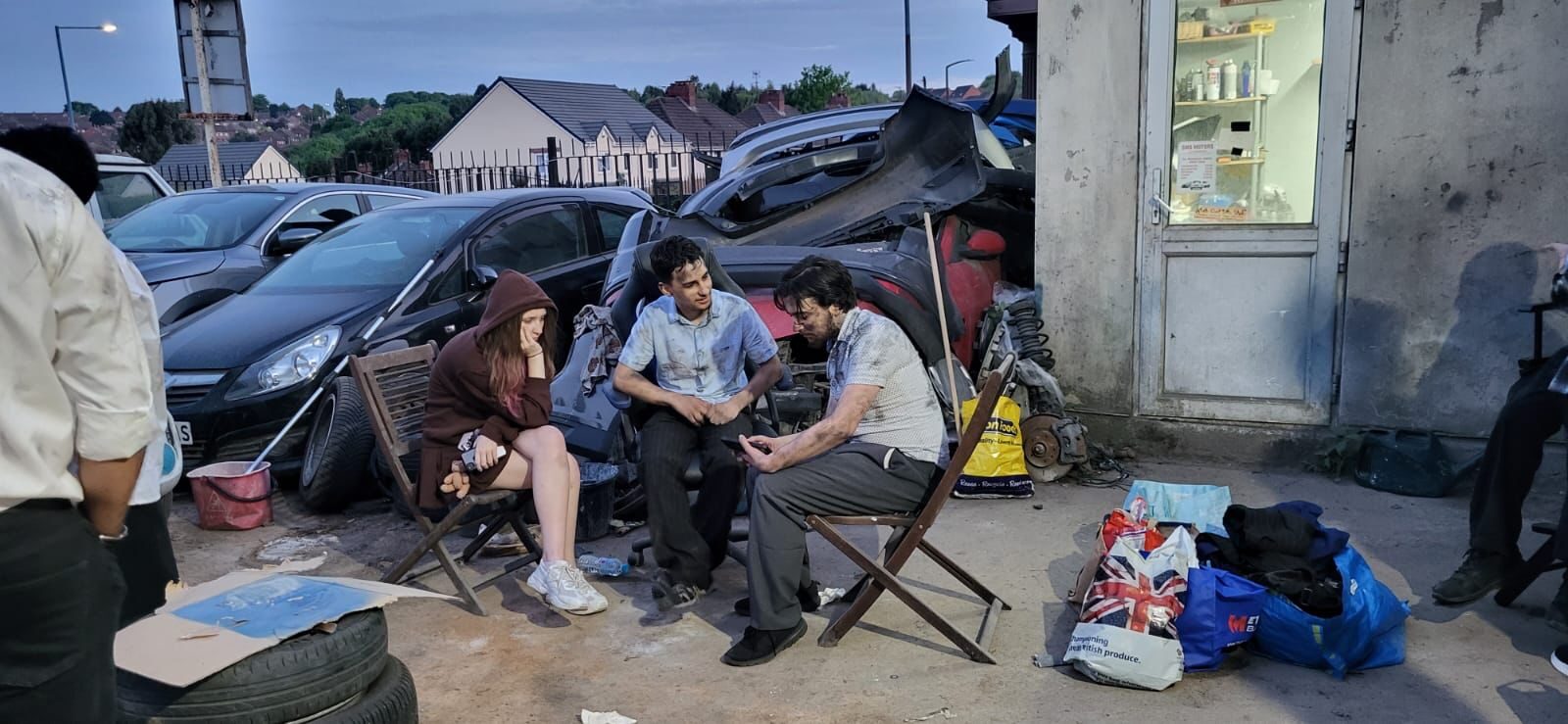Cast relaxing between takes at the Dayshift scrapyard location