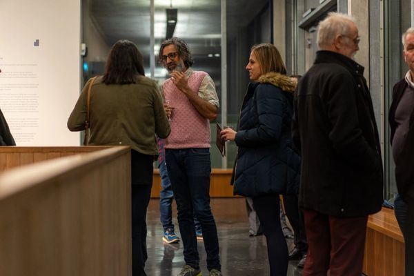 Visitors pointing at details within an Exiles photograph