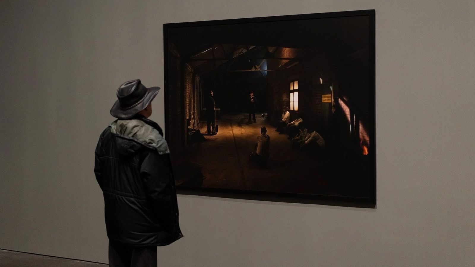 Visitor viewing a large-format Exiles photograph in the gallery