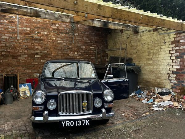 Period Austin car in a brick garage — vehicle props for the production