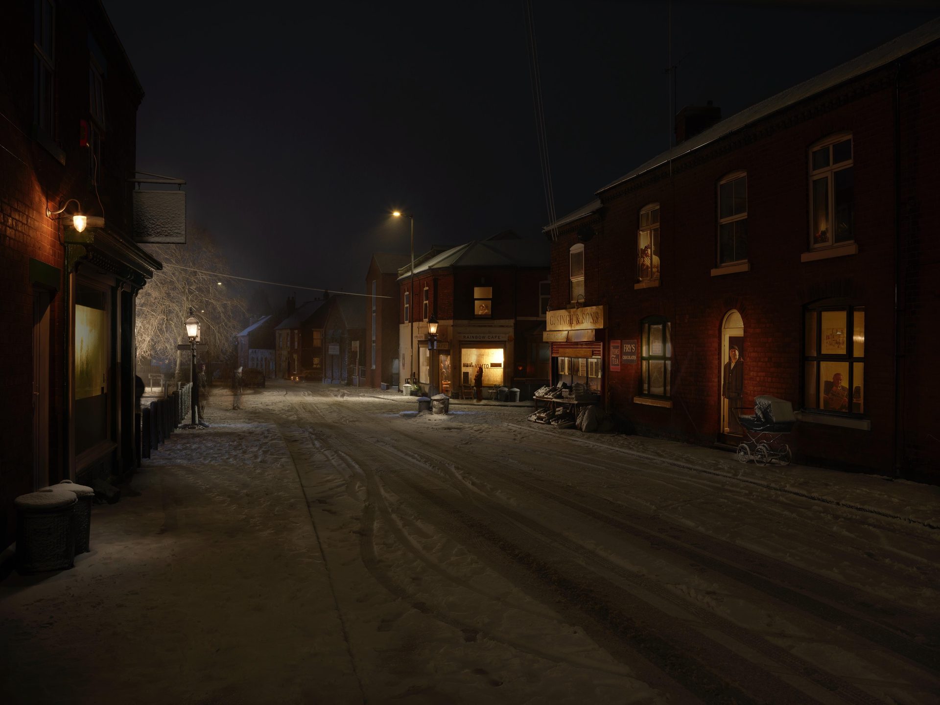 Snow-covered period street at night — warm lamplit shopfronts on The Butts, Walsall